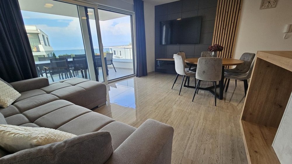 Zona giorno con grande vetrata e vista sulla terrazza e sul mare