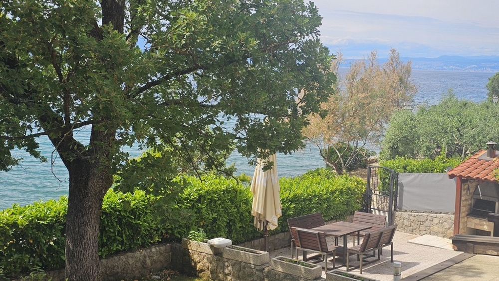 Terrazza sul mare con ombrellone e zona salotto a Malinska
