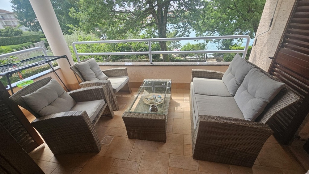 Balcone coperto con mobili lounge e vista mare