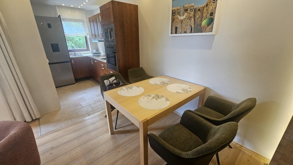 Zona pranzo con tavolo in legno e vista sulla cucina