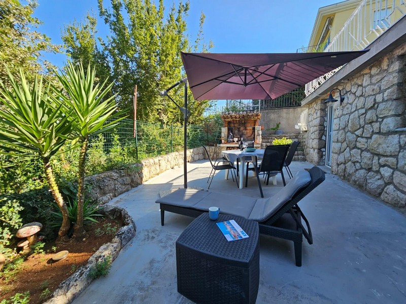 Terrazza con lounge e ombrellone dell'appartamento al piano terra a Njivice