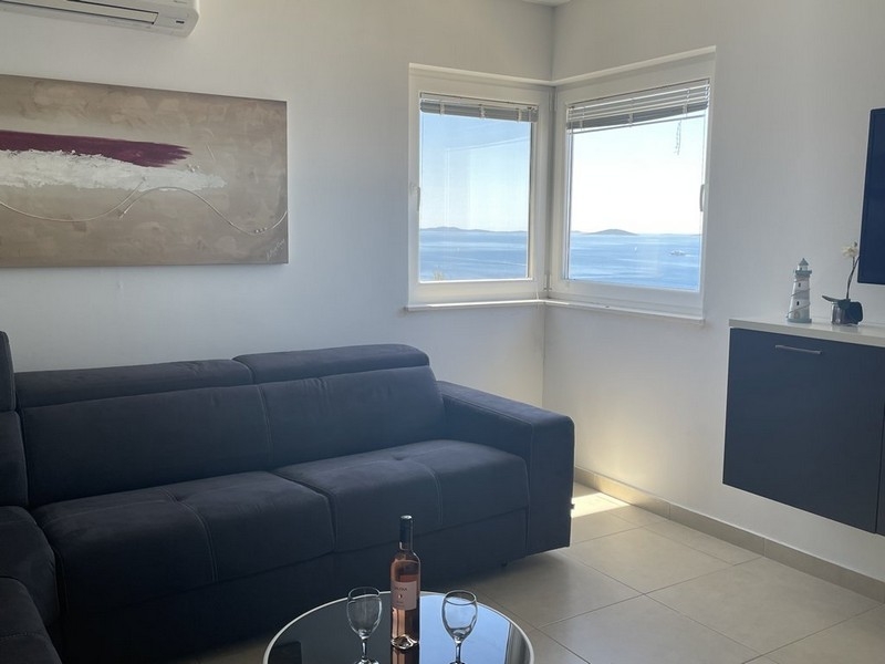 Zona giorno con aria condizionata e vista mare in un appartamento a Murter