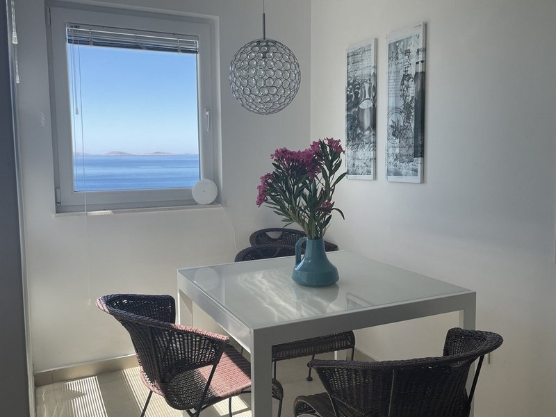 Zona pranzo con vista mare in un appartamento arredato a Murter