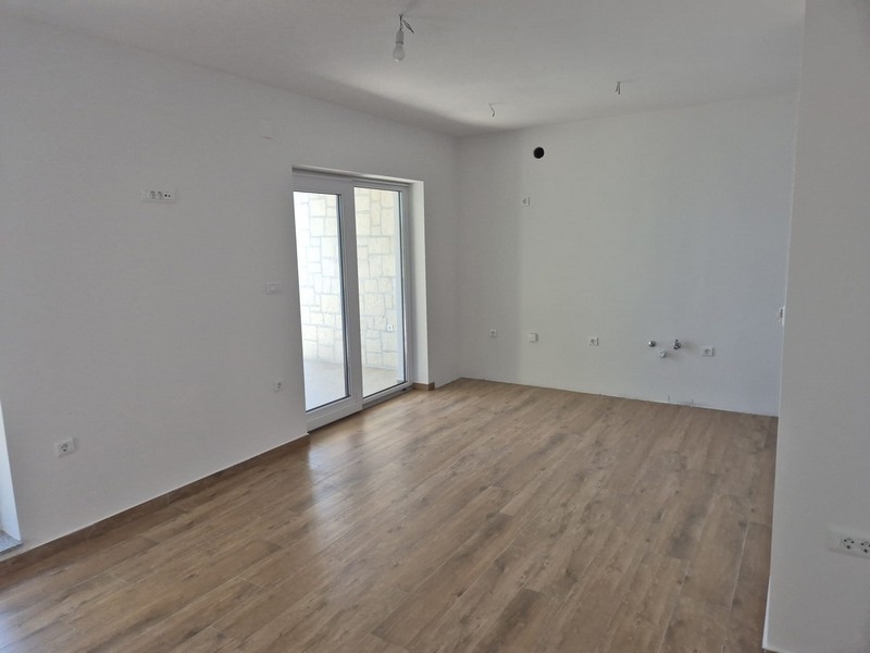 Locale con due porte e pavimento in legno chiaro