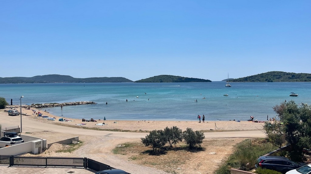 Spiaggia di ghiaia e vista mare davanti alla nuova costruzione a Srima vicino a Vodice