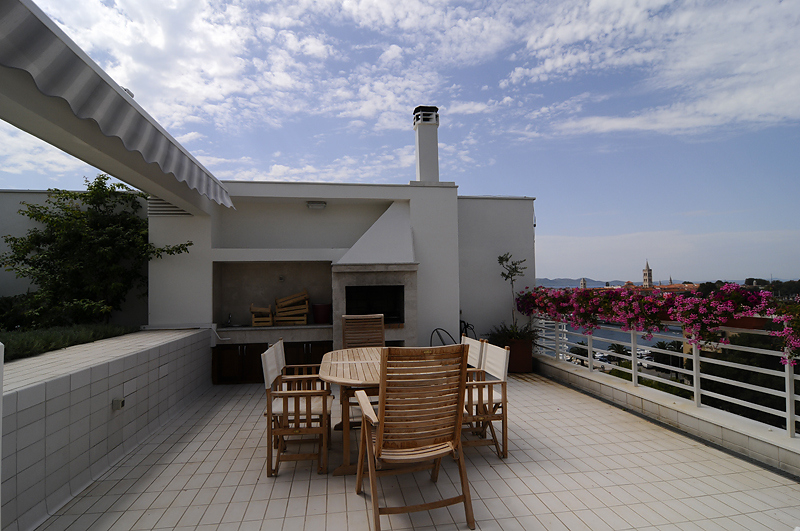A questo attico appartengono un giardino e una piscina sulla terrazza sul tetto al 6° piano.
