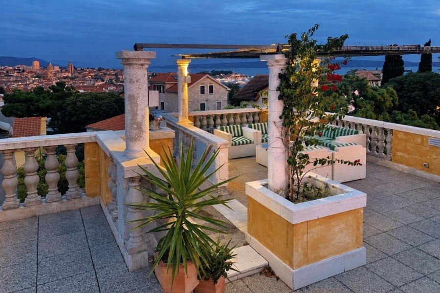 Terrazza sul tetto dell'attico a Split con piante e vista serale