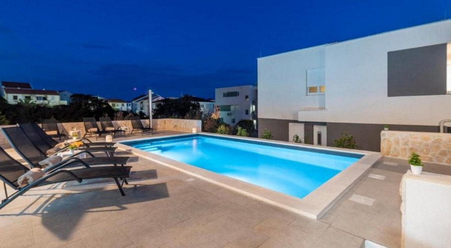 Piscina del complesso residenziale a Novalja la sera