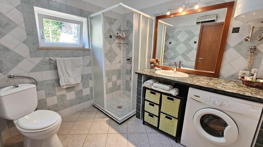 Bagno con doccia e lavatrice