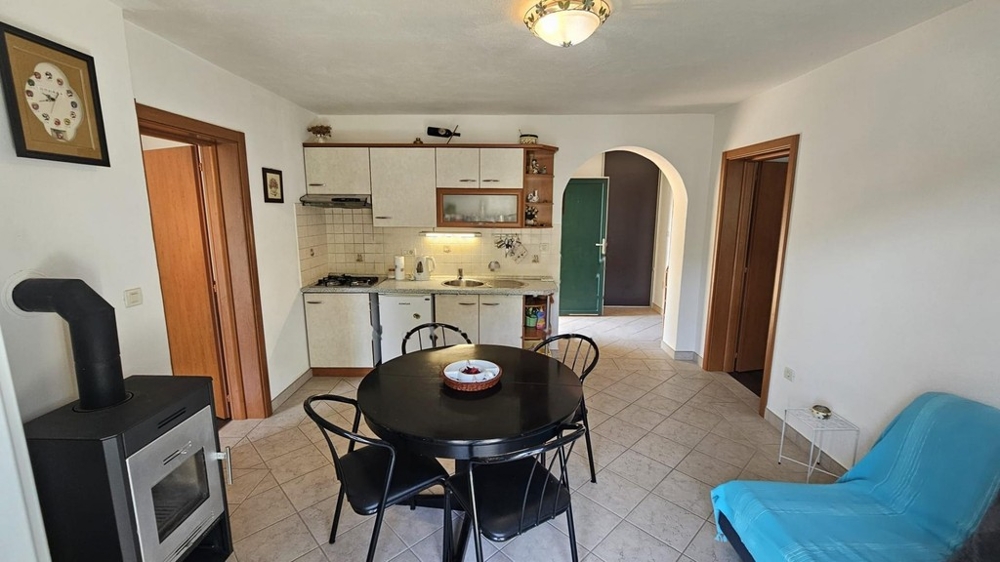 Cucina con zona pranzo e stufa a legna nella zona giorno