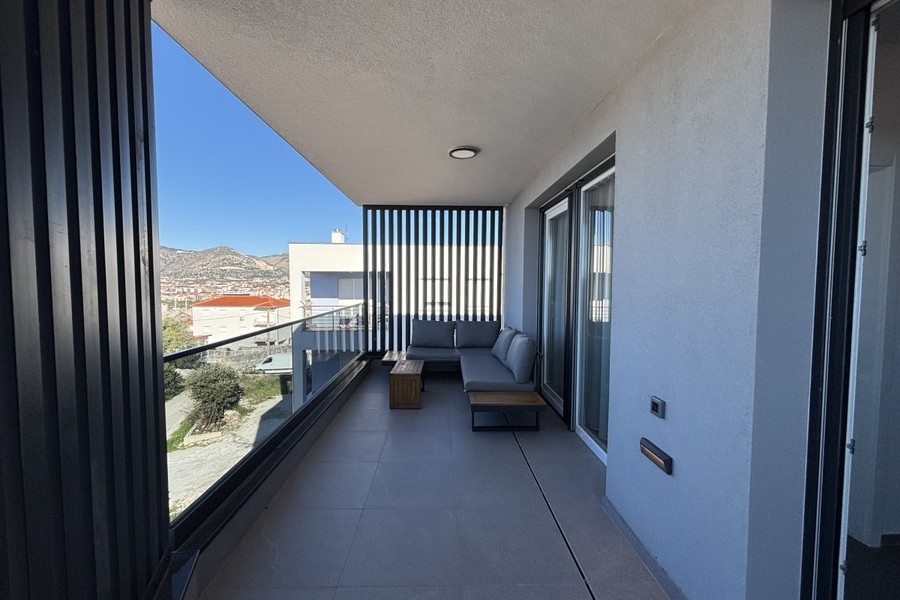 Balcone con divano e tavolo nell'attico a Trogir su Ciovo