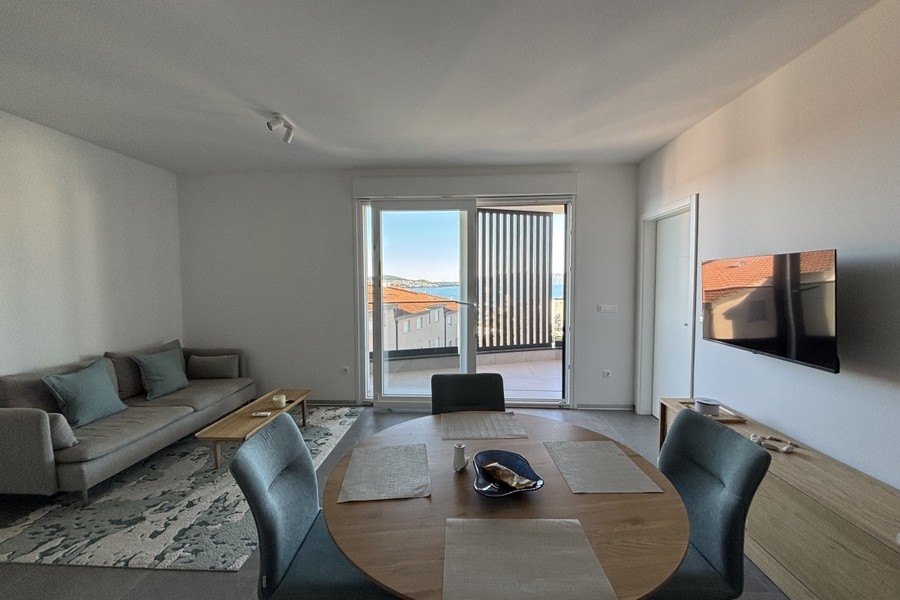 Soggiorno con divano e accesso al balcone a Trogir su Ciovo