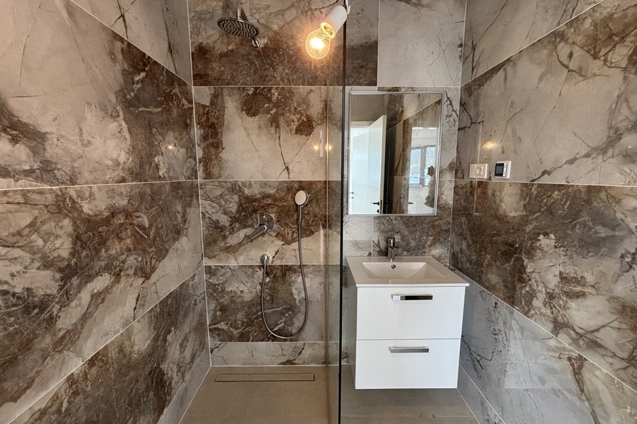 Bagno con doccia e piastrelle in marmo