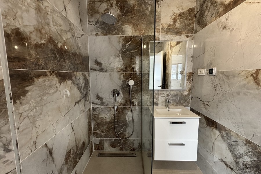 Altro bagno con piastrelle chiare in pietra naturale