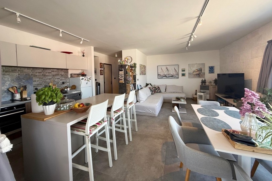 Zona giorno aperta con cucina e isola