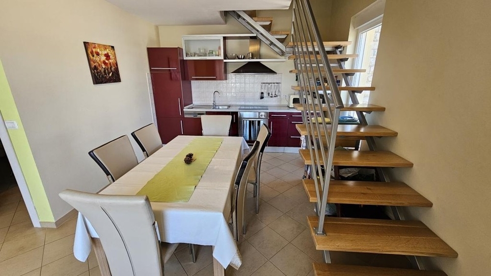 Zona pranzo con cucina e scala per il sottotetto
