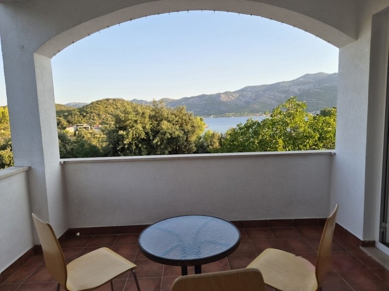 Loggia con arco a tutto sesto, tavolo e sedie