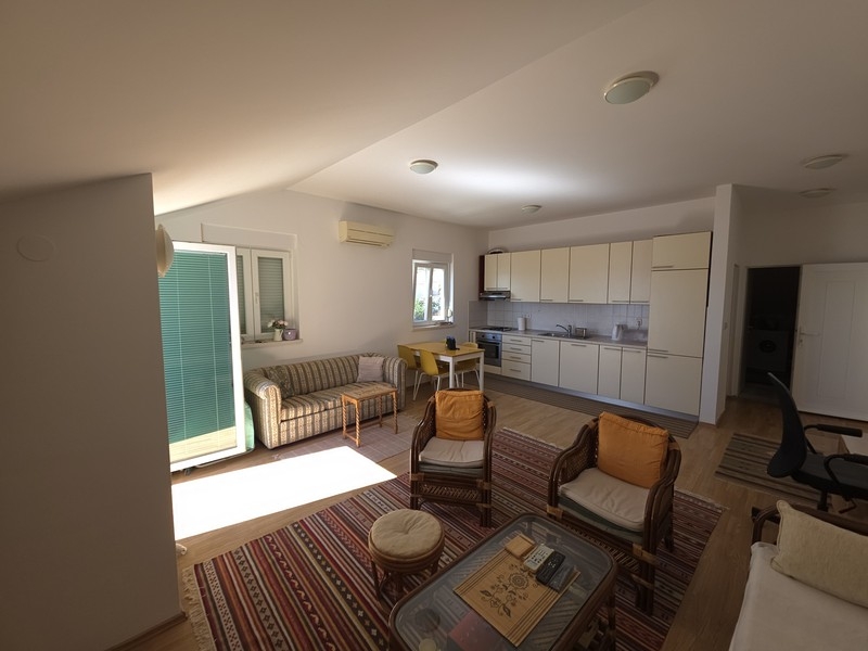 Zona giorno aperta con cucina e porta della terrazza