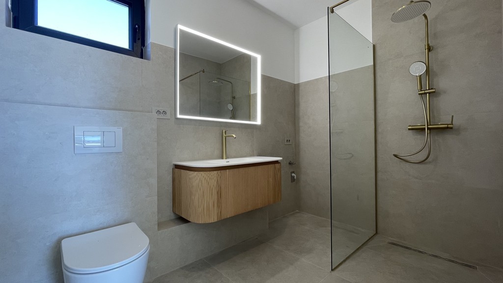 Bagno con doccia a pioggia e specchio illuminato