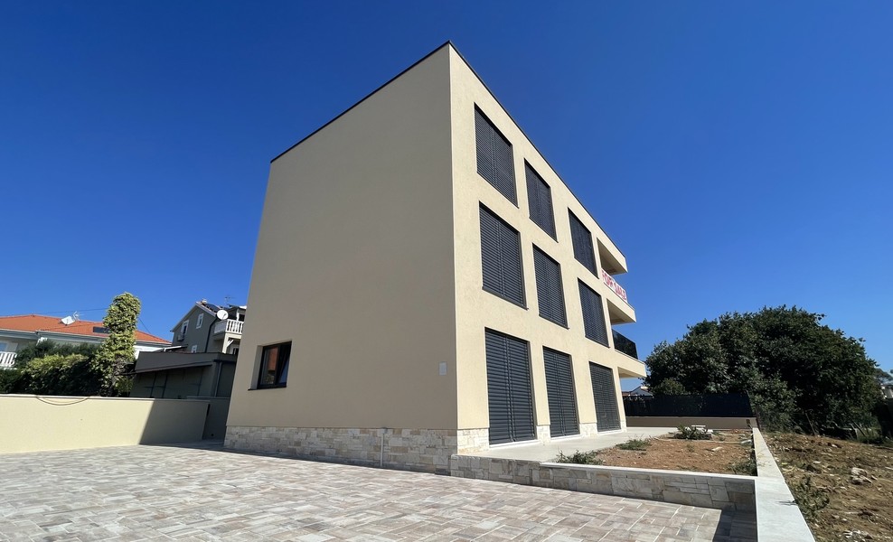 Vista laterale dell'edificio con cortile pavimentato