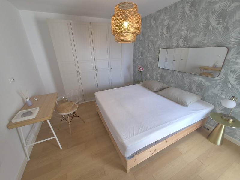 Letto matrimoniale davanti a una carta da parati decorata
