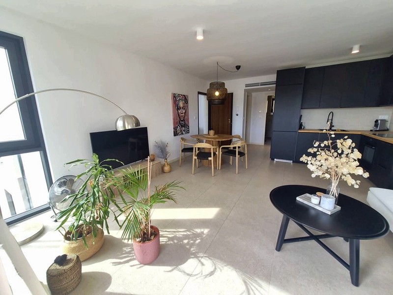 Zona giorno a pianta aperta con cucina sullo sfondo