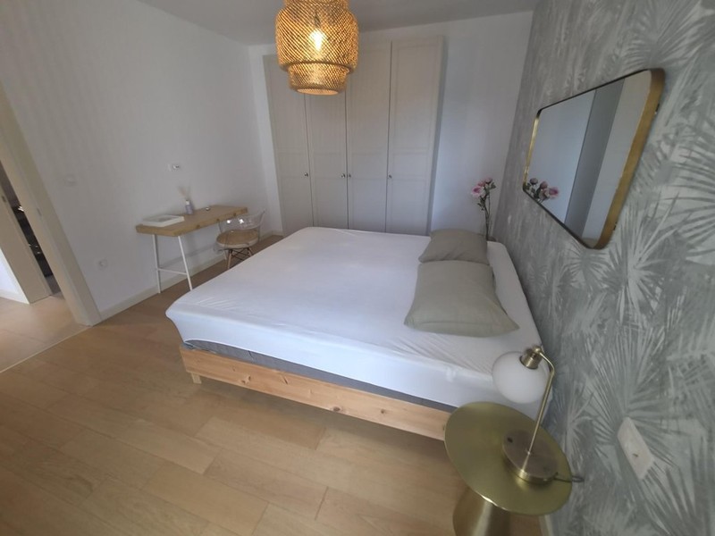 Camera da letto con letto matrimoniale e specchio a parete