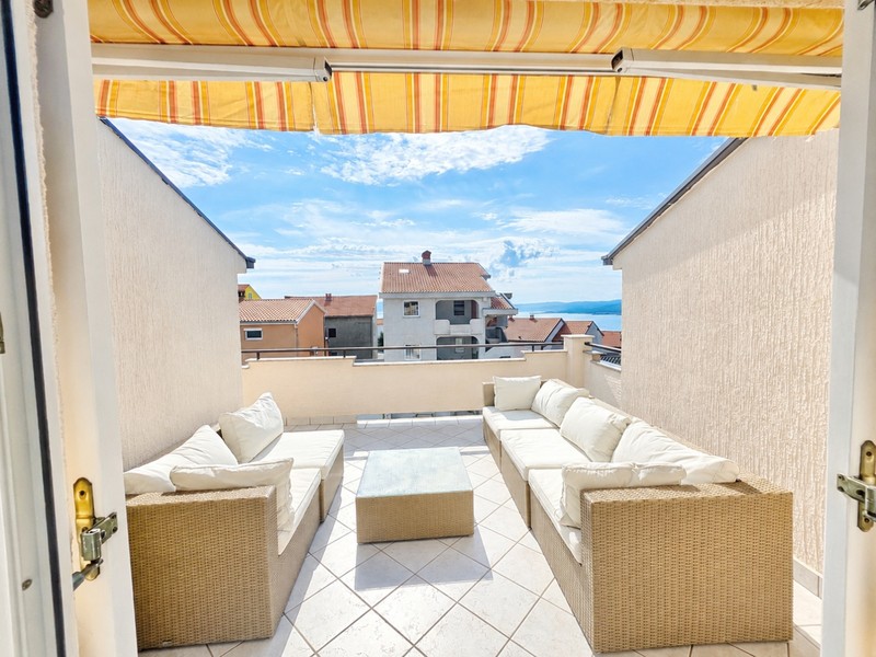 Terrazza con tenda da sole e salottino
