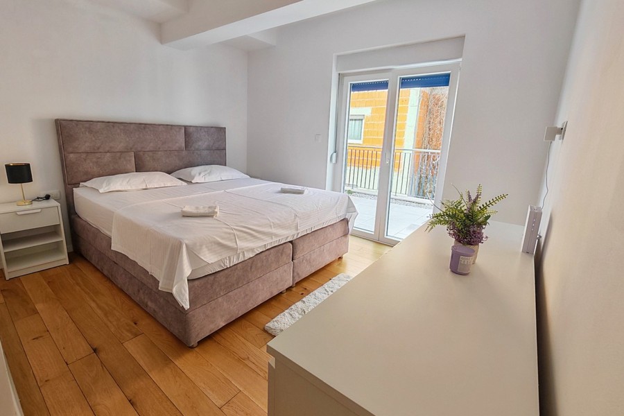 Camera da letto con letto matrimoniale e pavimento in legno