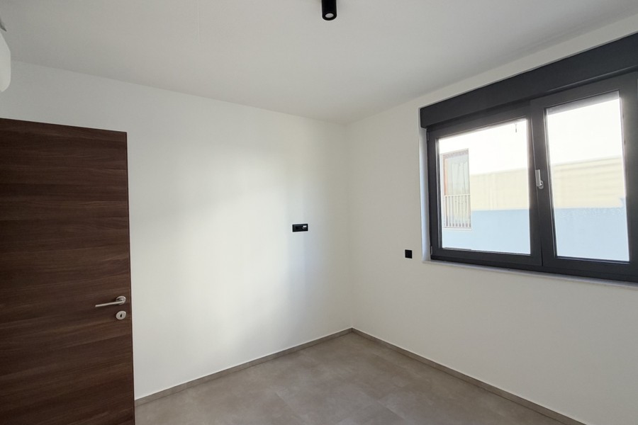 Camera da letto con porta in legno e finestra sulla strada
