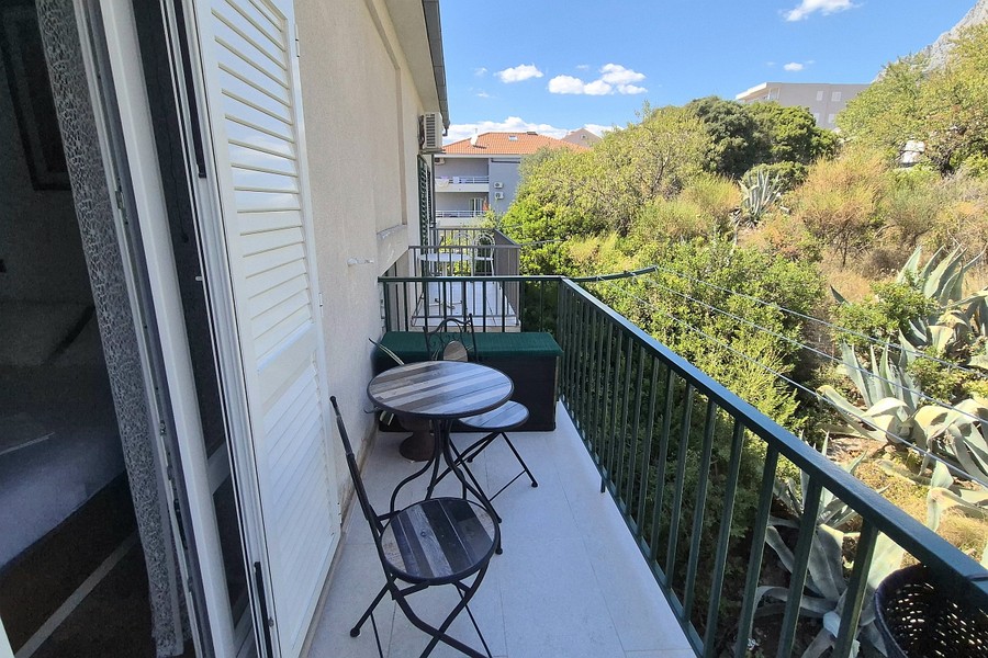 Balcone con tavolino bistrot e vista sul verde
