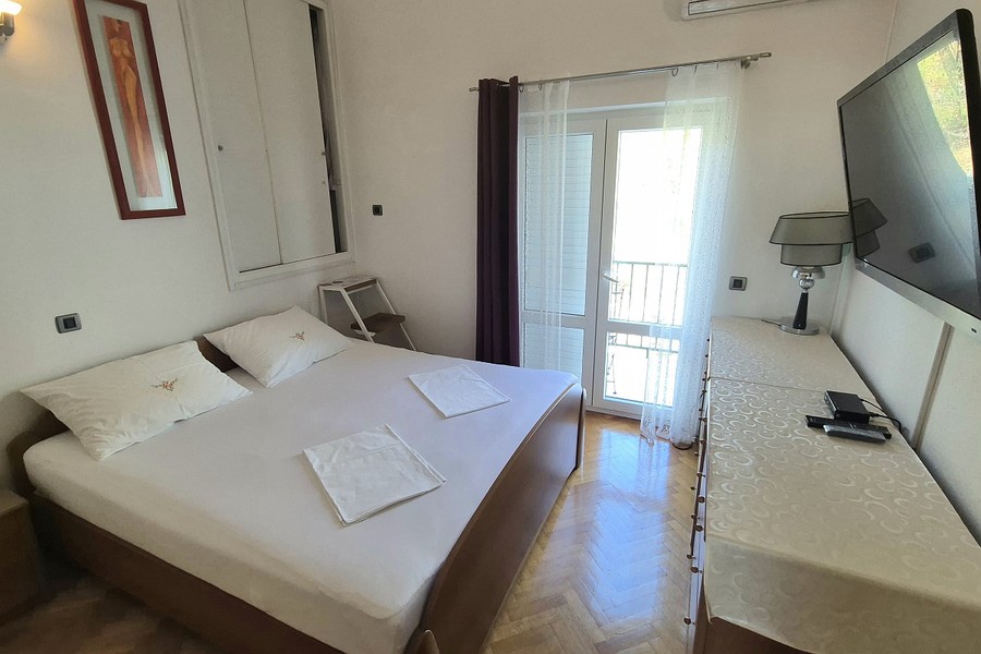 Camera da letto con letto matrimoniale e porta-finestra sul balcone
