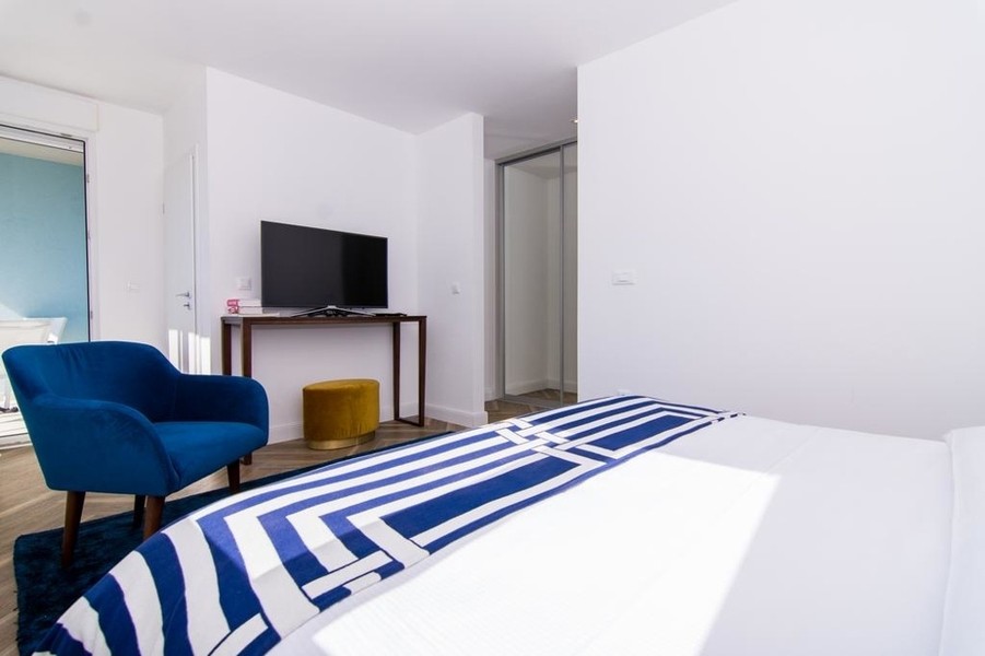 Camera da letto con poltrona e televisore