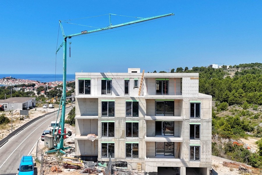 Cantiere con gru, sulla sinistra il centro storico sul mare