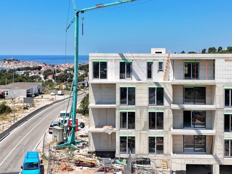 Cantiere con gru, sullo sfondo il centro storico sul mare