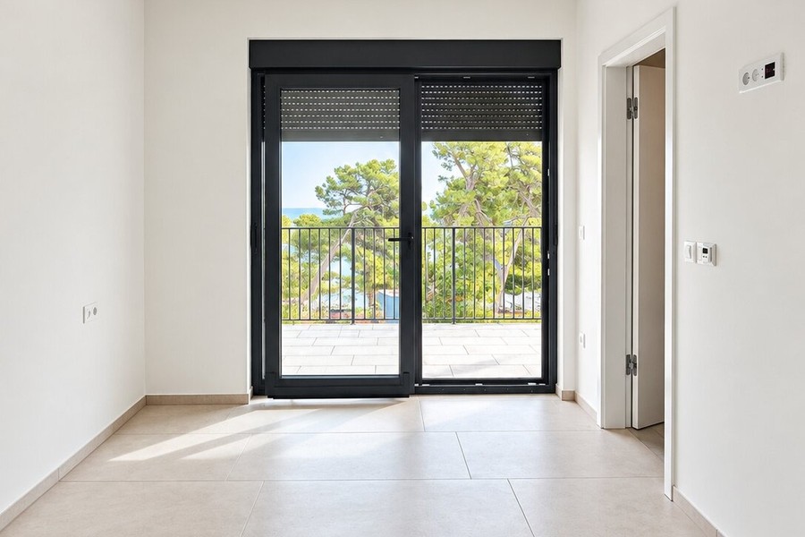 Camera da letto con porta-finestra sul balcone e vista sul verde