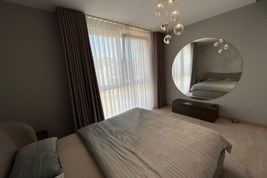 Camera da letto con specchio a parete e tende