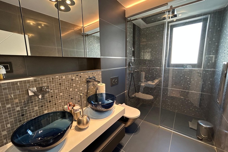 Bagno con due lavabi in vetro e doccia