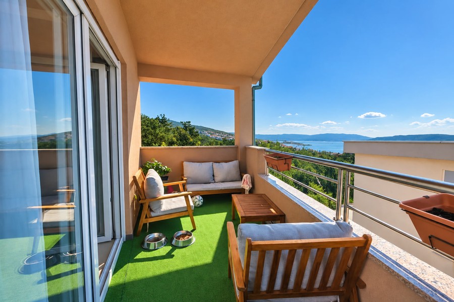 Balcone con mobili in legno e vista sul mare