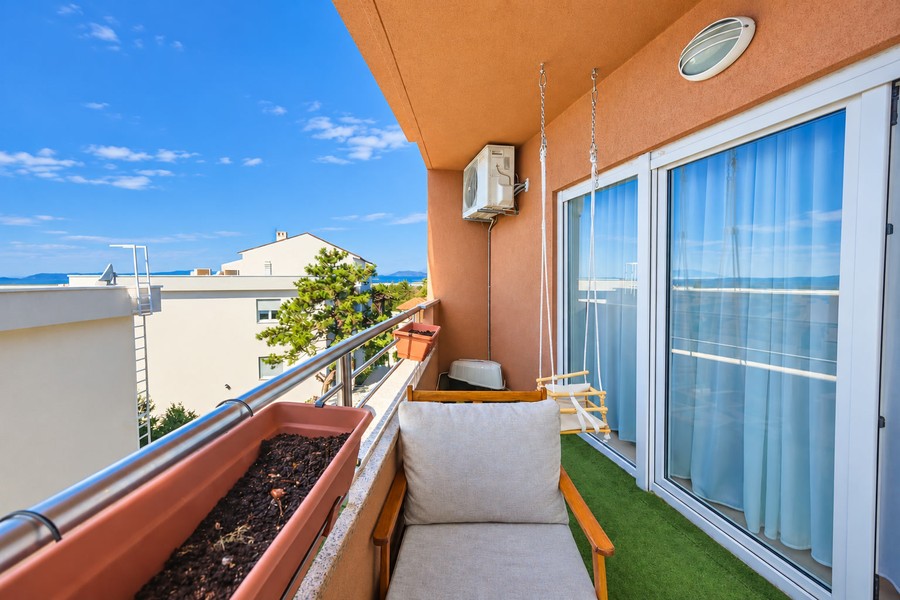 Balcone con poltrona e porta-finestra