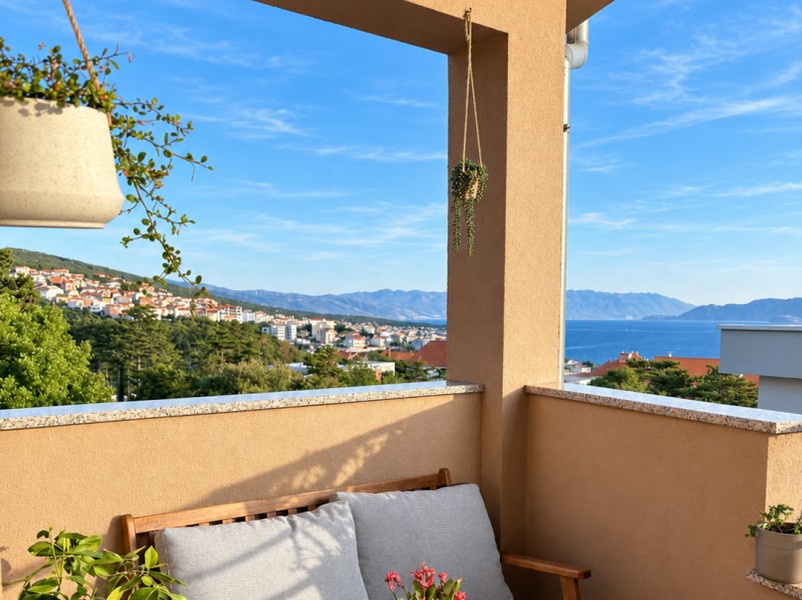 Angolo salotto sul balcone con vista sul paese
