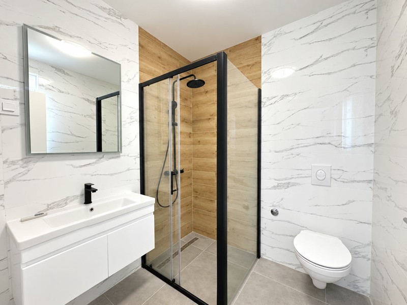 Bagno con doccia a pioggia e finitura in legno