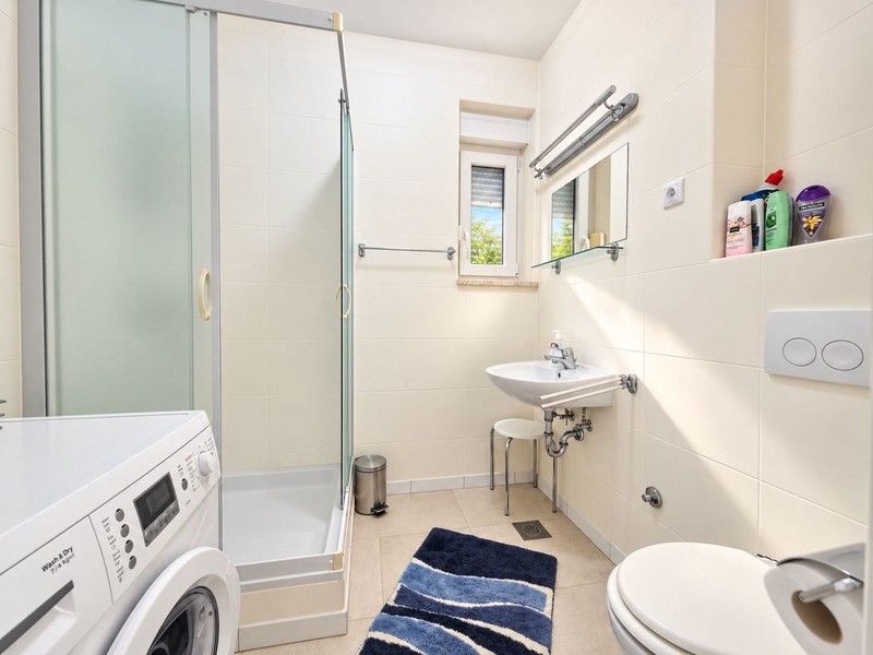 Bagno con doccia e lavatrice
