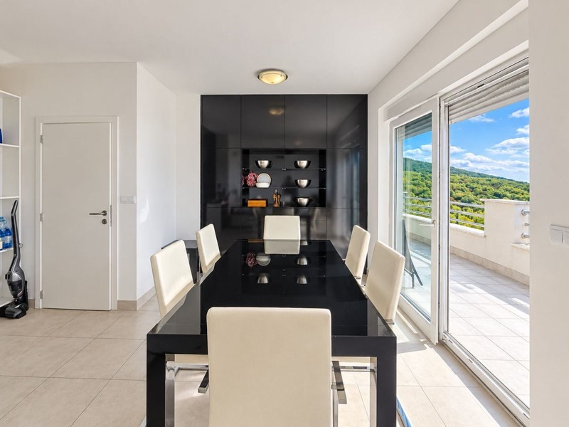 Tavolo da pranzo con sedie bianche e porta sulla terrazza