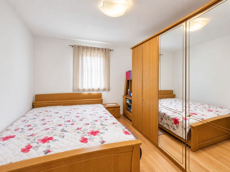 Camera da letto con letto matrimoniale e armadio con specchio