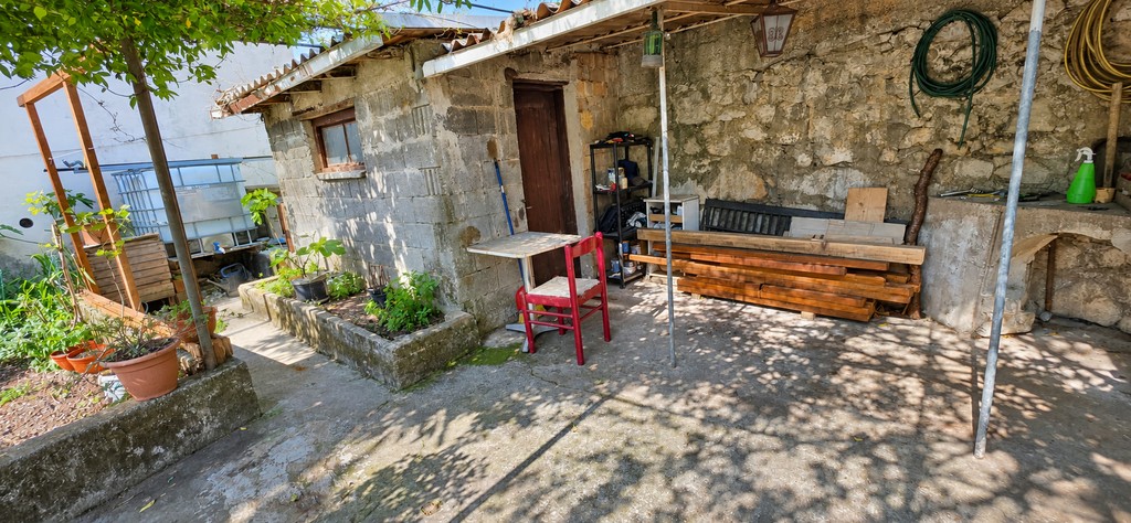 Casa in pietra nel giardino con tavolo e sedie