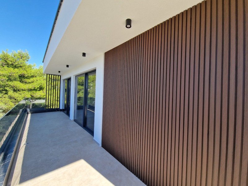 Loggia con rivestimento in legno e vista sul verde