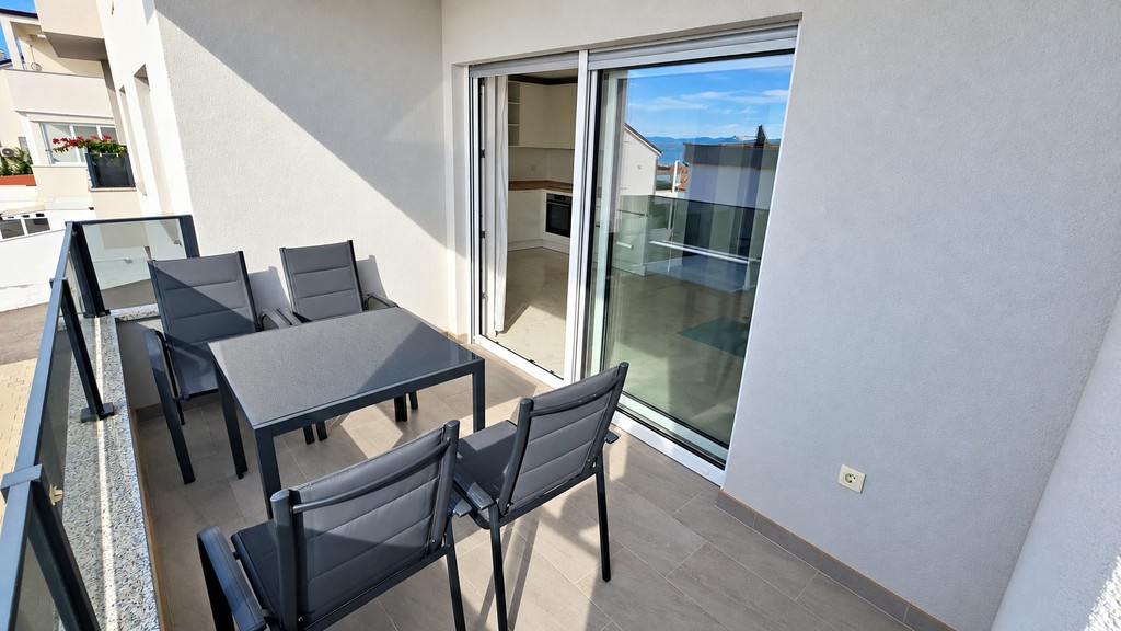 Loggia coperta con tavolo da pranzo e porta scorrevole