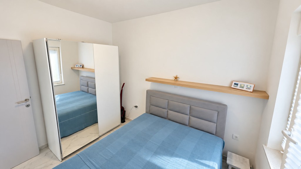 Camera da letto con armadio a specchio e letto matrimoniale