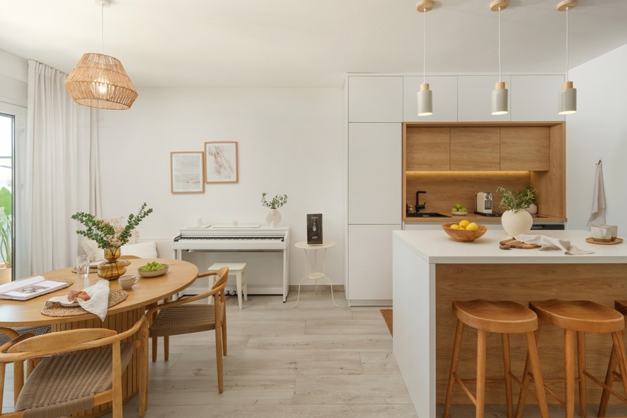 Zona pranzo con tavolo in legno e isola cucina